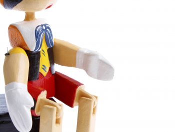 Wooden pinocchio on plain background