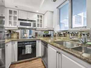 140 Simcoe St #304 kitchen with stainless steel appliances, white cabinets, and a window over the sink