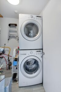 441 Jane St #410 utility room with stacked washer and dryer