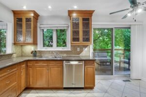 Eat-in kitchen at 12 Vistaview Blvd with sliding glass doors opening to a deck surrounded by trees.