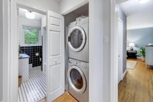 Laundry area with stacked washer and dryer located near the main bathroom at 12 Vistaview Blvd.