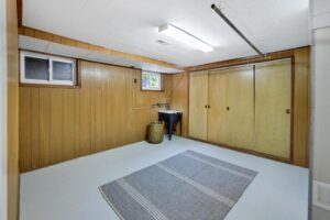 Finished lower-level bonus room with large closets and wood panel walls at 12 Vistaview Blvd.